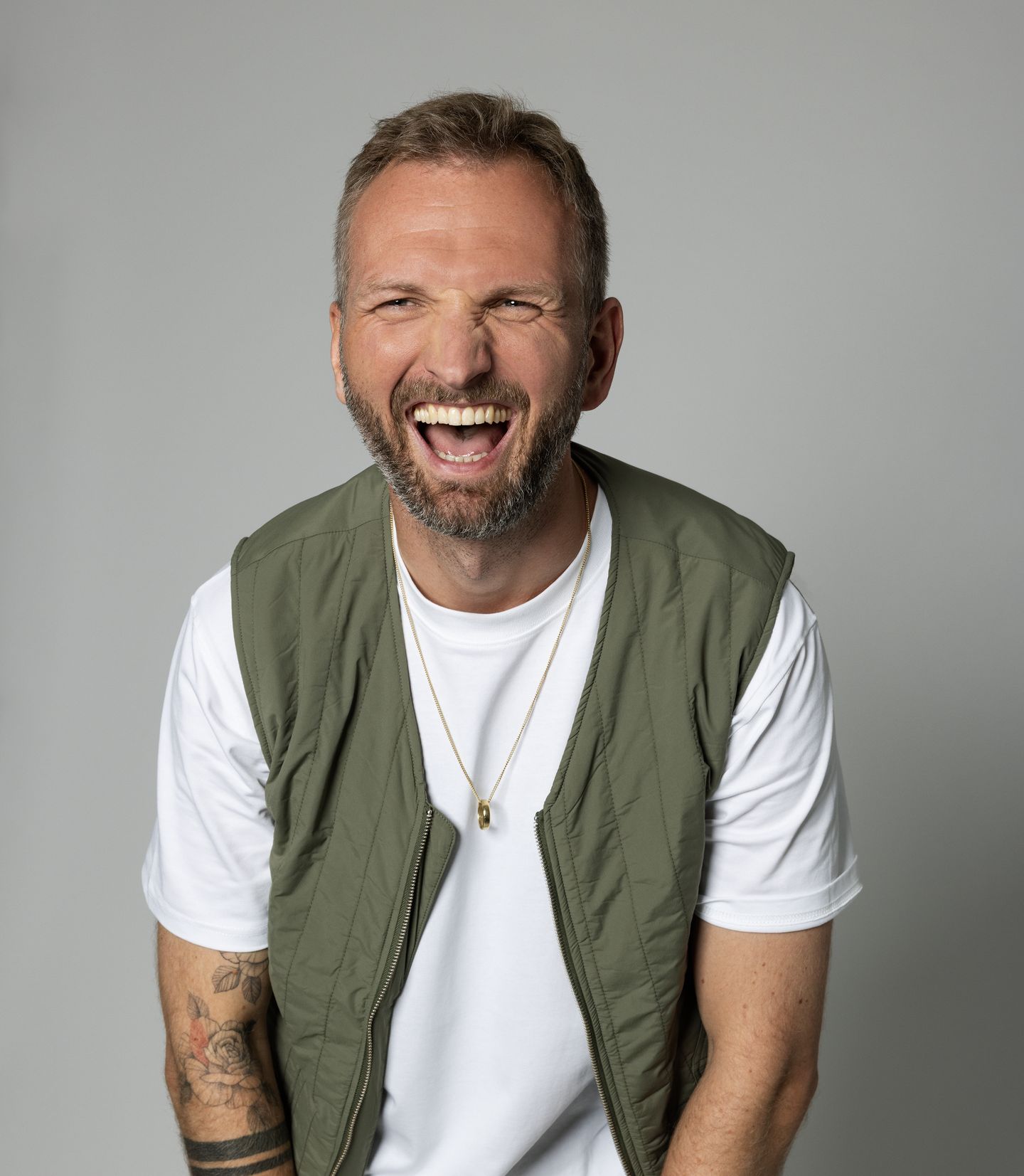 Pieter schatert het uit, in wit T-shirt en groen bodywarmer